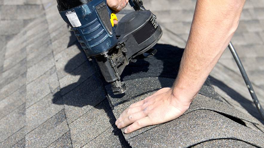 Roofer applying emergency repairs after storm
